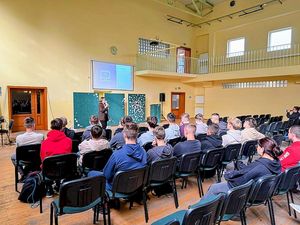 Na zdjęciu znajduje się policjantka "po cywilnemu", która przeprowadza prelekcję.
Na sali znajduje się młodzież. funkcjonariuszka wyświetla pokaz slajdów