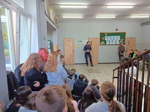 Na zdjęciu jest policjantka, która przeprowadza prelekcję dla dzieci o bezpieczeństwie.