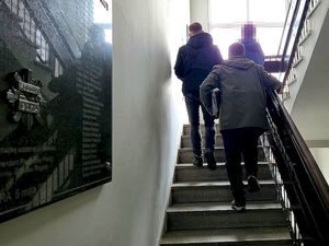 Funkcjonariusze Wydziału Kryminalnego prowadza osobę zatrzymana po schodach