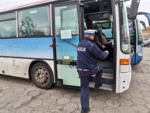 funkcjonariusz kontrolujący przestrzeganie zasłaniania nosa i ust w autobusie